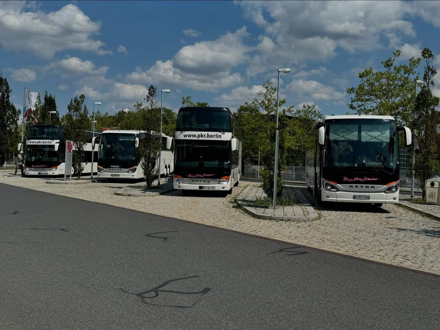 Several coaches side by side in a car park, among them coaches of Prima Klima Reisen