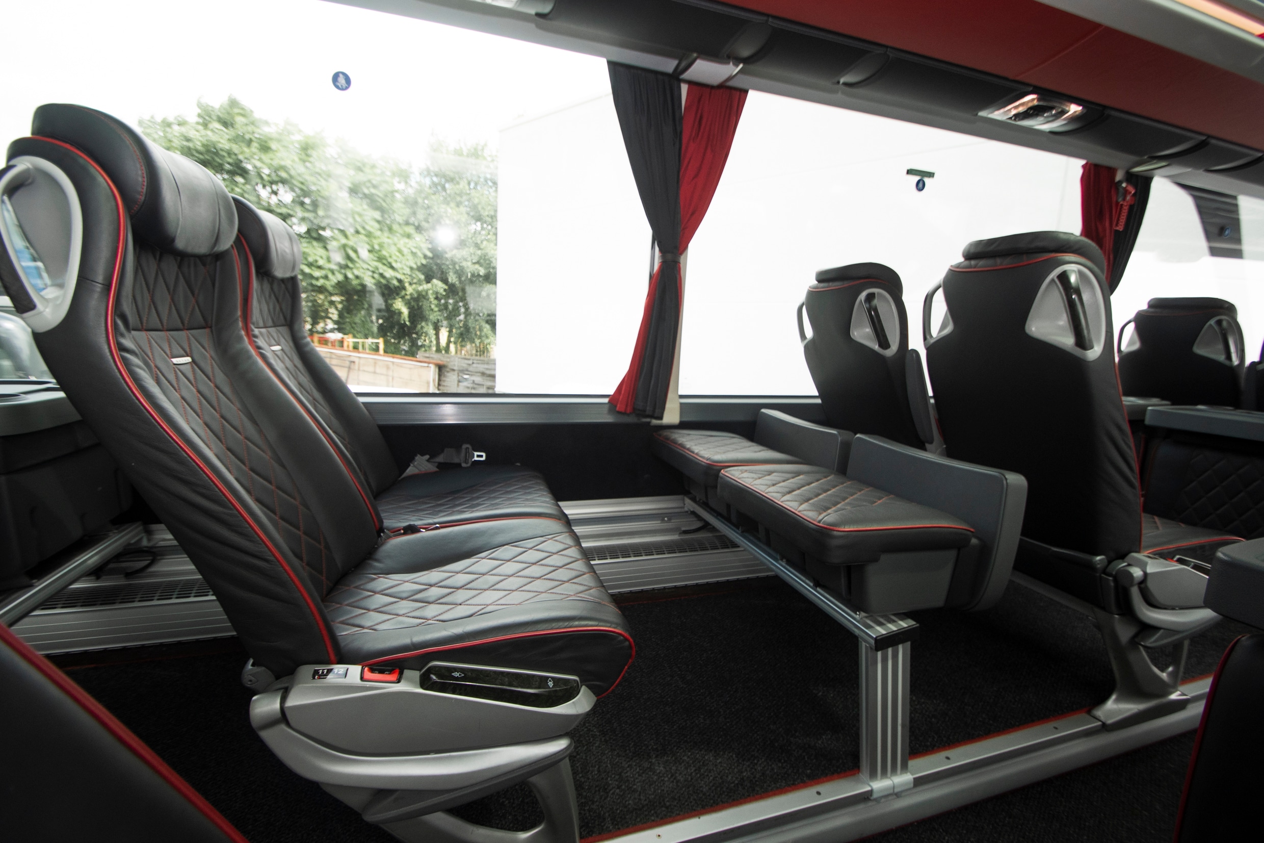 Teambus interior: leather seats with footrest by the window